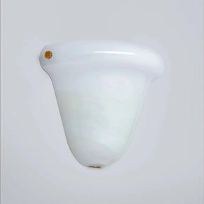 A vintage-style white glass wall sconce with a flared, bell-shaped shade and a small gold screw detail on the left side, shown against a plain light gray background.