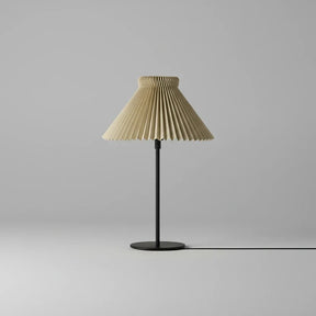 Table lamp with pleated beige shade on a gray background