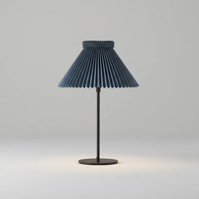 Table lamp with pleated blue shade on a white background