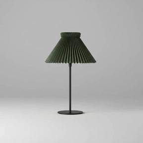Table lamp with pleated green shade on a gray background